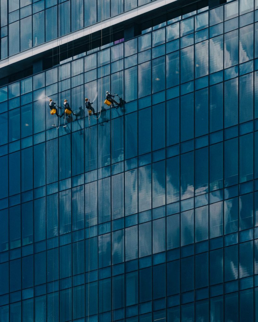Window cleaners work on a modern glass building