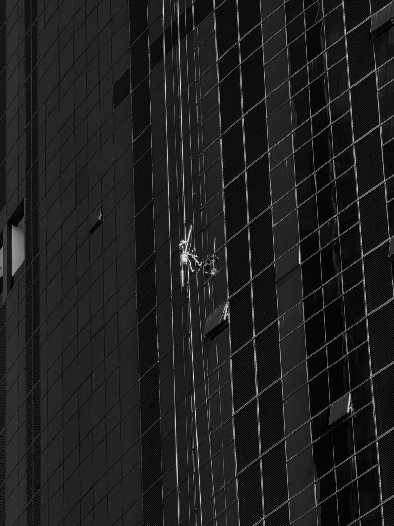 Window cleaners work on a skyscraper's glass facade.